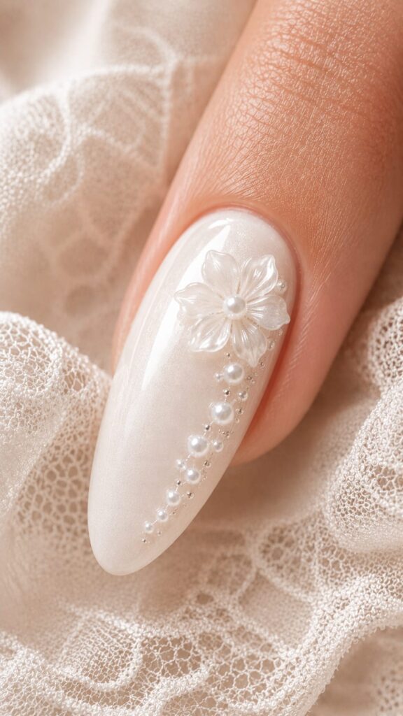 Uña con flor 3D nacarada con cascada de perlas en degradé para novia elegante en tendencia