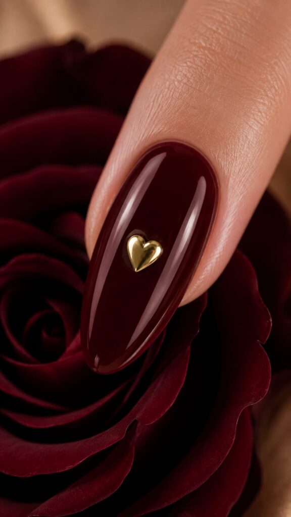 Uña borgoña con corazón dorado para novia elegante en tendencia